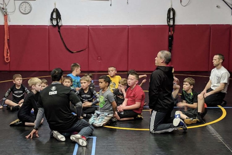 Coach Adrian talks to the kid wrestlers.